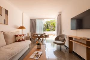 a living room with a couch and a table at S'Argamassa Boutique Hotel in Santa Eularia des Riu
