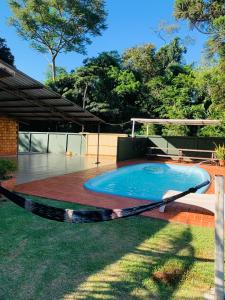 a swimming pool with a hammock in a yard at Casa Nina, com Piscina e Brinquedoteca, Super Próxima das Cataratas e Aeroporto in Foz do Iguaçu