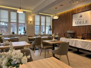 a dining room with tables and chairs and windows at Villa Adele in Polanica-Zdrój