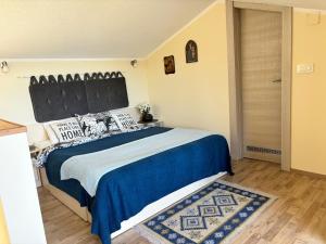 a bedroom with a large bed with a blue comforter at Patrick House in Tivat