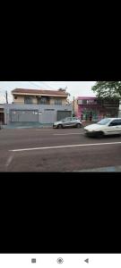 a white car driving down a street next to a building at Espaço Ideal 6 in Cascavel