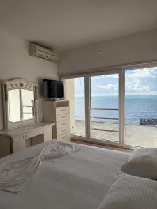a bedroom with a bed and a view of the ocean at Blumont aparthotel durres in Durrës