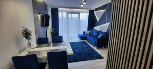a living room with a blue couch and a table at FRANKO APARTAMENTS - Hanza Tower in Szczecin +60 photos