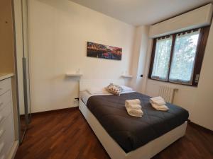a bedroom with a bed with two towels on it at Lavilletta stanza parco in Baranzate
