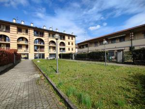a building with two street lights in front of a yard at Lavilletta stanza parco in Baranzate