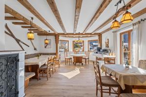a restaurant with tables and chairs and windows at Gästehaus Florian in Grainau
