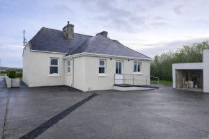 a white house with a large parking lot at John's Farmhouse in Kilrush