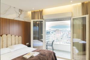 a hotel room with a bed and a balcony at Luxury City View Apartments with Balcony & Kitchen & Fast Wi-Fi in Shkodër +36 photos