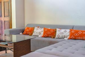 a blue couch with orange and white pillows on it at Playa Cielo Beachfront Hotel - Santa Teresa, Costa Rica in Santa Teresa Beach