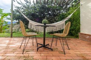 two chairs and a hammock on a patio at Hotel Alma in Tinjacá