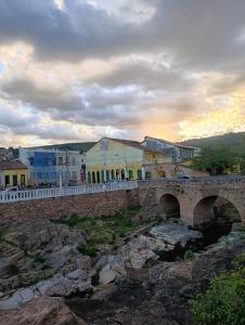 a bridge over a river with buildings in the background at Cantinho do Pequeno Arthur in Lençóis