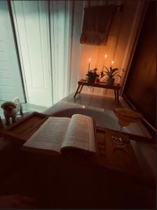 an open book on a bed with a table with candles at Kèbi Container Home near Blue Falls in Colonia