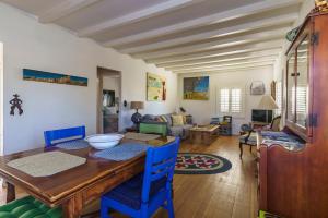 a living room with a wooden table and blue chairs at Cactus Adobe in Twentynine Palms