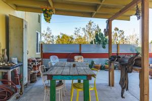 a wooden table and chairs on a patio at Cactus Adobe in Twentynine Palms