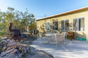 a patio with a table and chairs next to a building at Cactus Adobe in Twentynine Palms