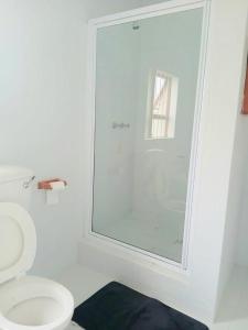 a bathroom with a toilet and a glass shower at Sea Breeze Manor - Sage Unit in East London +6 photos