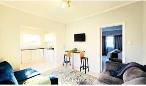 a living room with a couch and a kitchen at Sea Breeze Manor - Sage Unit in East London