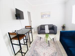 a living room with a table and a couch at Sea Breeze Manor - Sage Unit in East London