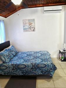 a bedroom with a bed with a blue blanket at Nadiyah's Escape in Rock Sound