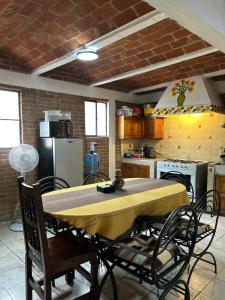 eine Küche mit einem Tisch, der mit einer gelben Tischdecke bedeckt ist in der Unterkunft Casa Ttorrez in San Miguel de Allende