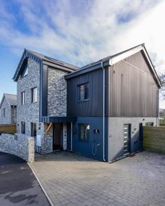 a house with a blue and gray facade at Uno Carbis Bay - Boutique Luxury Accommodation in Carbis Bay