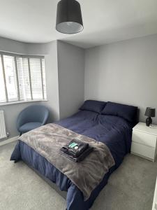 a bedroom with a blue bed and a blue chair at Ravenscourt House in Bristol