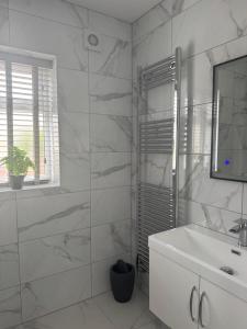 a white bathroom with a sink and a mirror at Ravenscourt House in Bristol +13 photos