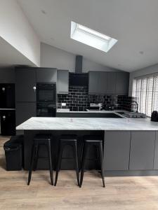 a kitchen with a large counter with stools in it at Ravenscourt House in Bristol