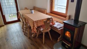 a kitchen with a table and a wood stove at Casa Vacanze Tel 121 in Pieve Tesino