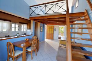 a kitchen and dining room with a wooden table and a spiral staircase at Vagia Beach Apartments, Aegina Island in Vaia