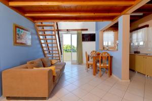a living room with a couch and a dining room at Vagia Beach Apartments, Aegina Island in Vaia