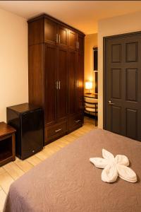 a bedroom with a bed with two white towels on it at Hotel Boutique 4 Estancias in San Ramón +15 photos