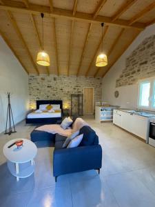a living room with a blue couch and a bed at Casa Diatsenta in Bogdanátika
