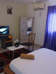 a bedroom with a bed and a tv and a chair at AMI House I in Mamoudzou