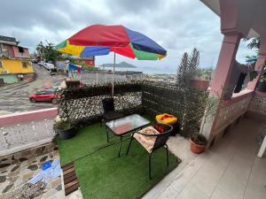 a patio with a table and an umbrella on a balcony at AMI House I in Mamoudzou