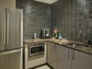 a kitchen with a stainless steel refrigerator and a sink at Loews Chicago Hotel in Chicago