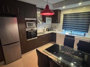 a kitchen with brown cabinets and a red light at Vila Praia House in Vila Praia de Âncora