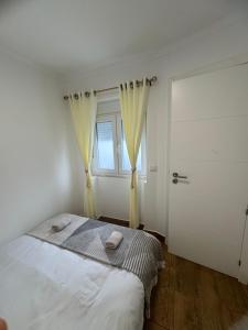 a white bedroom with a bed and a window at Cascais Garden House 102 in Cascais +4 photos