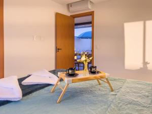 a room with a bed with a table on it at Duplex com Piscina Privativa em Itacimirim! in Camaçari +26 photos