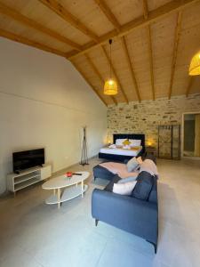a living room with a blue couch and a bed at Casa Diatsenta in Bogdanátika