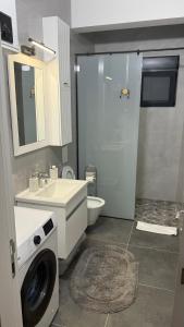 a bathroom with a sink and a washing machine at Morea Apartments in Ulcinj +26 photos