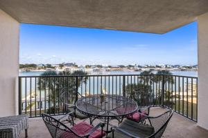 a balcony with a table and chairs and a view of the water at Wind Drift North 214 2BD, 2BA in Orange Beach