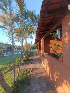 a walkway leading to a house with palm trees at Chalés Vale Encantado - Serra do Cipó in Jaboticatubas
