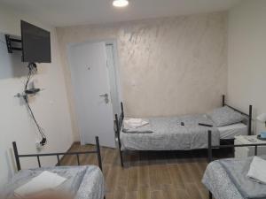a room with two beds and a television in it at Motel Gas in Belgrade