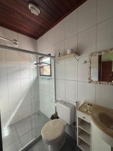a bathroom with a toilet and a shower and a sink at Bora Bora Geribá Kitnet in Búzios
