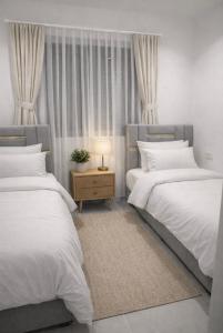 a bedroom with two beds and a table with a lamp at Casas Del Mar Cabo B8 in Martil +29 photos