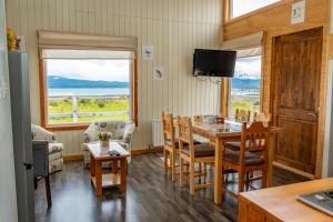 a dining room with a table and chairs and a television at Kayenwuouk, Puerto Natales in Puerto Natales