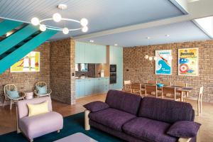 a living room with a purple couch and a kitchen at Motel Flinders in Flinders