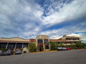 a parking lot with cars parked in front of a building at Hotel la Palapa Mazatlan in Mazatlán