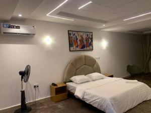 a bedroom with a white bed and a fan at Lushplus Living in Mama